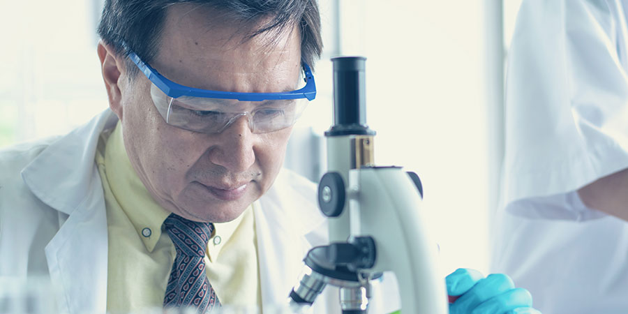 Persons of Extraordinary Ability - - An image of a scientist looking on the microscope - Ghazi Law Group