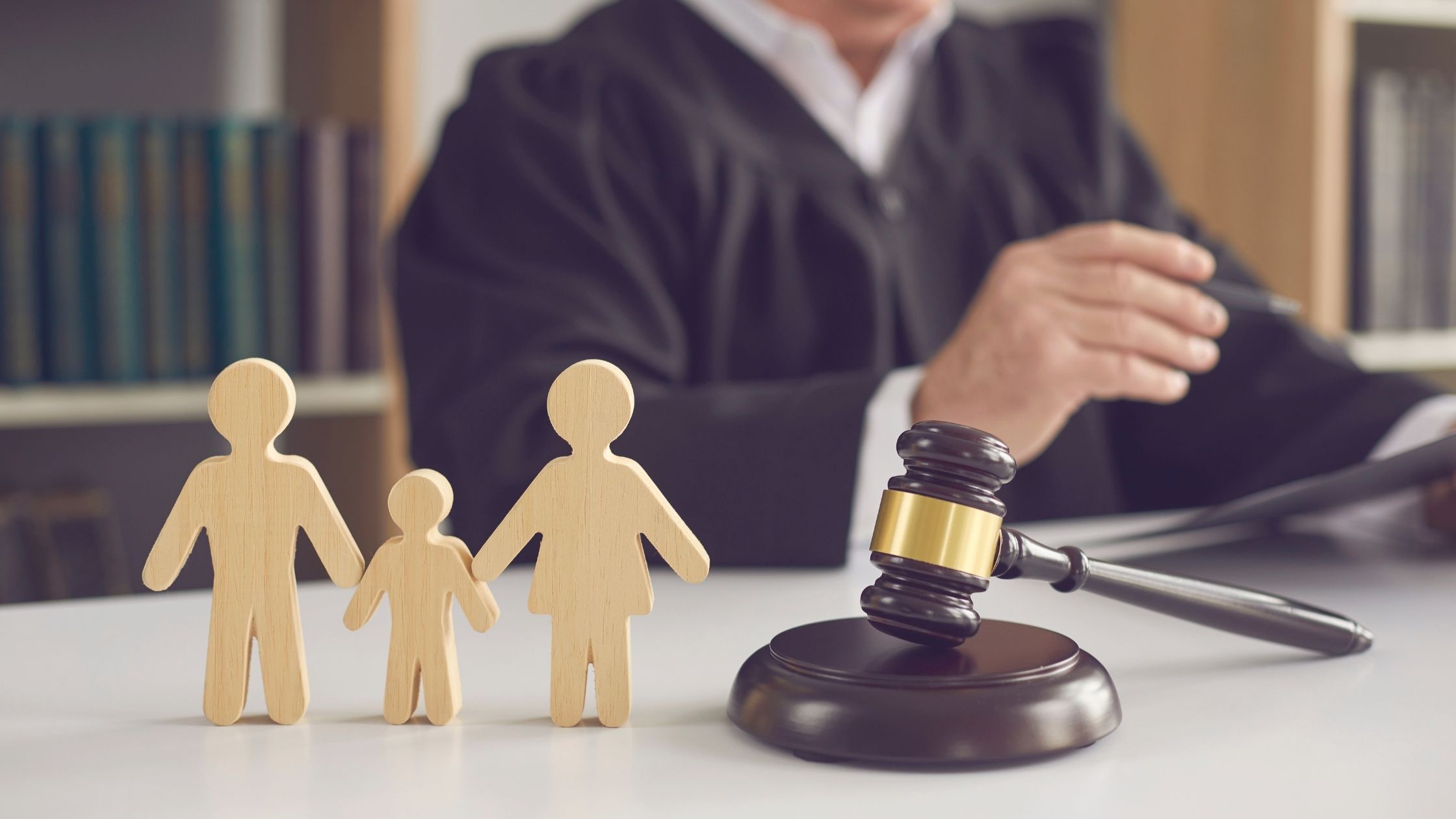 Image of family court judge, gavel, and wooden figure representing familes law clients - Ghazi Law Group