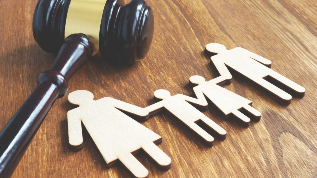 The Ins and Outs of California Family Law Attorney Fees - An Image of a wooden family of four with a gavel on their back - Ghazi Law Group